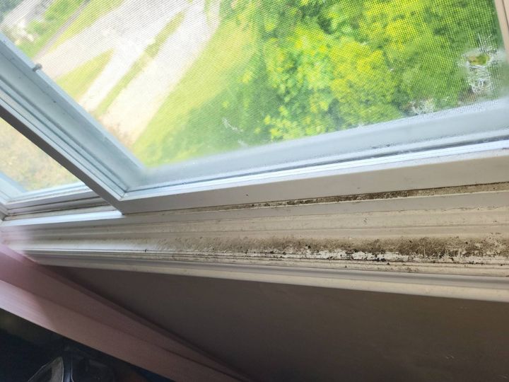 Residential windowsill before being cleaned. Covered in layer of black dirt, mould, grime.