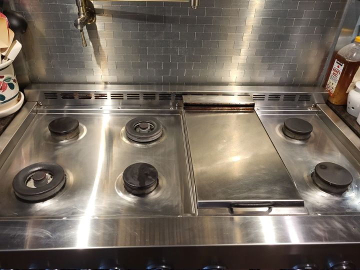 Residential stainless steel gas cooktop after being cleaned. Free of dirt, food, or grease, bright and shiny like new.