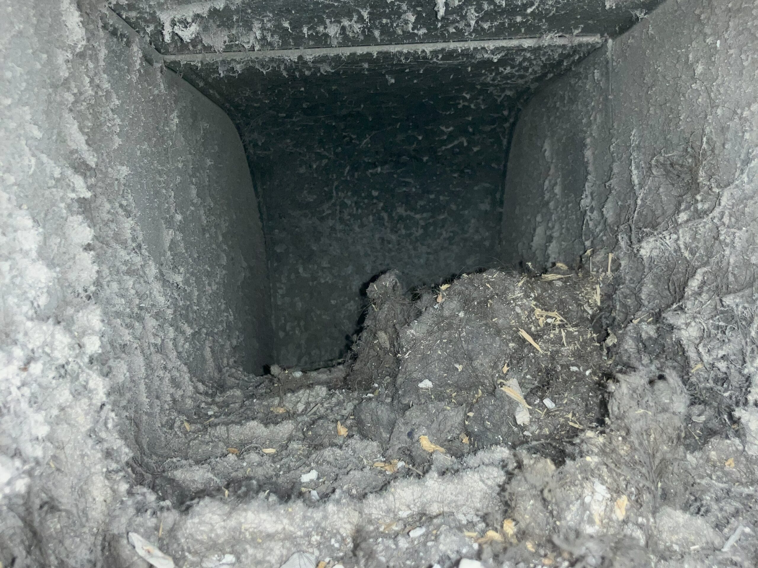 Inside metal ductwork before being cleaned. Clogged with years of dust, pet hair, and debris.